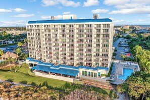 Un hôtel à plusieurs étages doté de balcons, d’une piscine et d’un espace paysager.