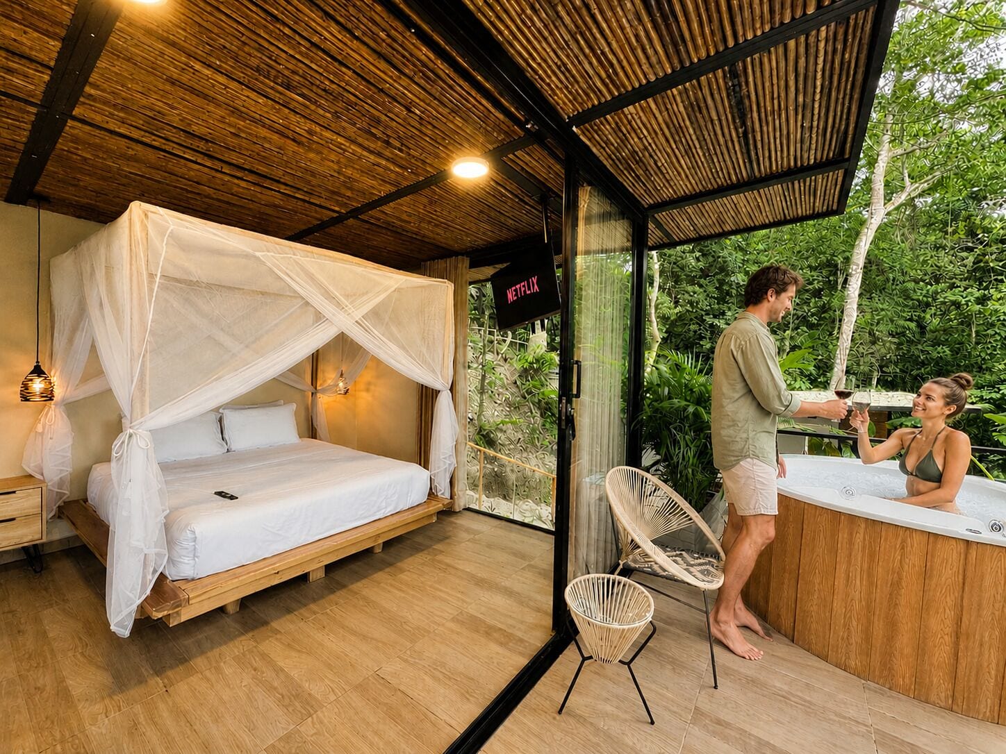 Una habitación con cama, puerta de vidrio que da al exterior, cartel de Netflix y zona de hidromasaje.