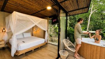 Una habitación con cama, puerta de vidrio que da al exterior, cartel de Netflix y zona de hidromasaje.