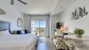 Camera d'albergo con un letto grande, una scrivania, una sedia e vista sulla città.