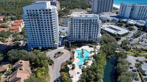 Un hotel moderno con molti piani, una piscina e vista sulla spiaggia.