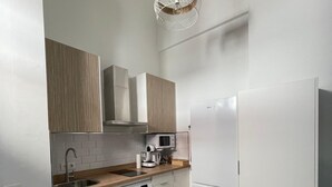 Una cucina moderna con lavatrice integrata, forno a microonde e frigorifero.