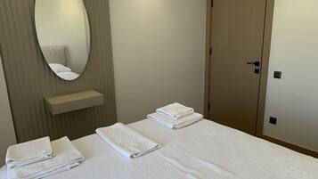 Ein Hotelzimmer mit einem großen Bett, einem Spiegel, einem Nachttisch und einer Klimaanlage.