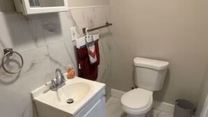 Ein Badezimmer mit weißem Waschbecken, Toilette und Marmorboden.