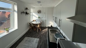 A compact kitchen with a dining area, a window, and a view of the outside. - Standard Double Ensuite (Skegness)