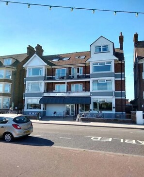 A multi-story building with a ground-level restaurant and upper residential units. - Standard Triple Ensuite (Skegness)