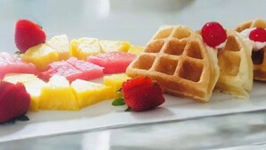 Um prato com waffles e frutas.