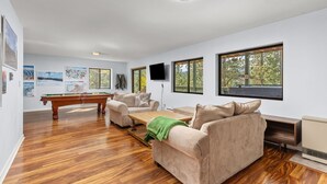 A spacious living room with a pool table, a sofa, and a television. - Hot Tub - Near Eldora - Views - Pool Table (Rollinsville)