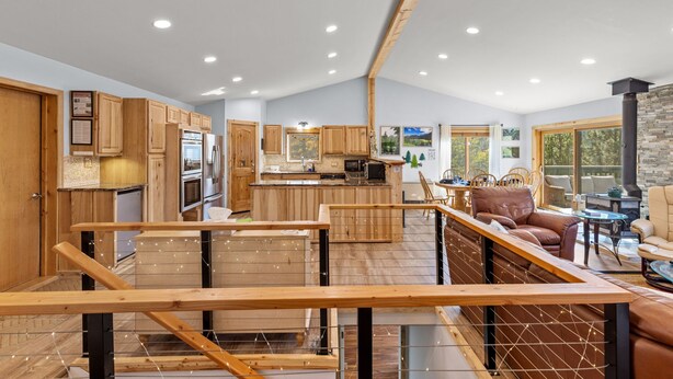 A spacious kitchen with wooden cabinets, a central island, and a dining area with a sofa and table. - Hot Tub - Near Eldora - Views - Pool Table (Rollinsville)