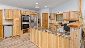 A modern kitchen with wooden cabinets, granite countertops, stainless steel appliances, and a central island. - Hot Tub - Near Eldora - Views - Pool Table (Rollinsville)
