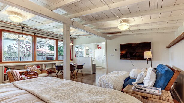 Quarto espaçoso com duas camas, área de refeições e cozinha ao fundo.