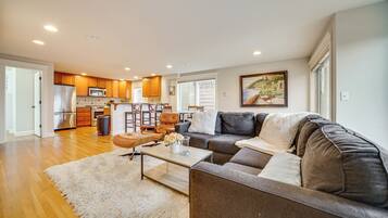 A modern living room with a sectional sofa, a coffee table, and a kitchen in the background.