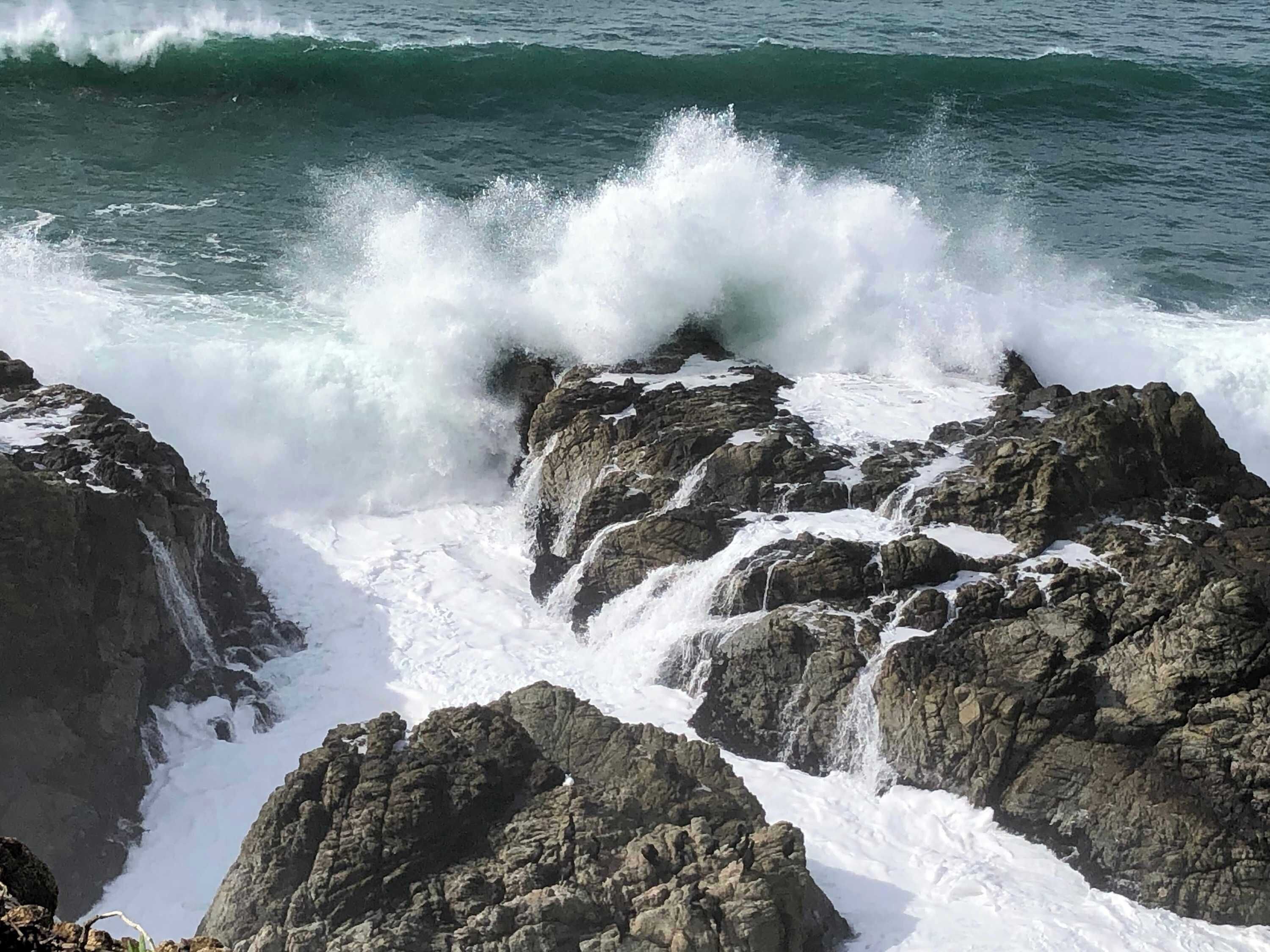 A rocky coastline with waves crashing against the rocks.