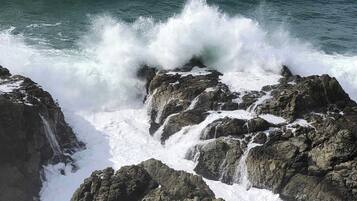 A rocky coastline with waves crashing against the rocks.