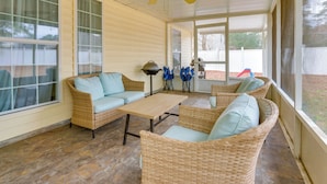 A covered patio with wicker furniture, a ceiling fan, and large windows. - 11 Mi to Savannah! Suburban Home w/ Spacious Yard (Pooler)