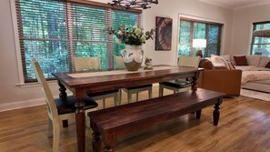 Un comedor con una mesa de madera, bancos y sillas.