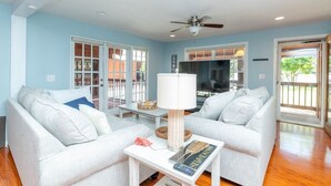 A living room with two white sofas, a coffee table, a lamp, and a ceiling fan. - Waterfront 3BR Villa w/ Gym/Pool & Dock Access (Riverview)