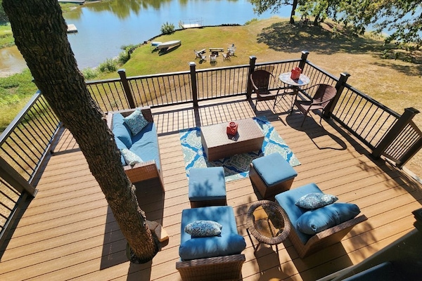 Lower deck seating area with cozy patio furniture and kayaks for guest use.