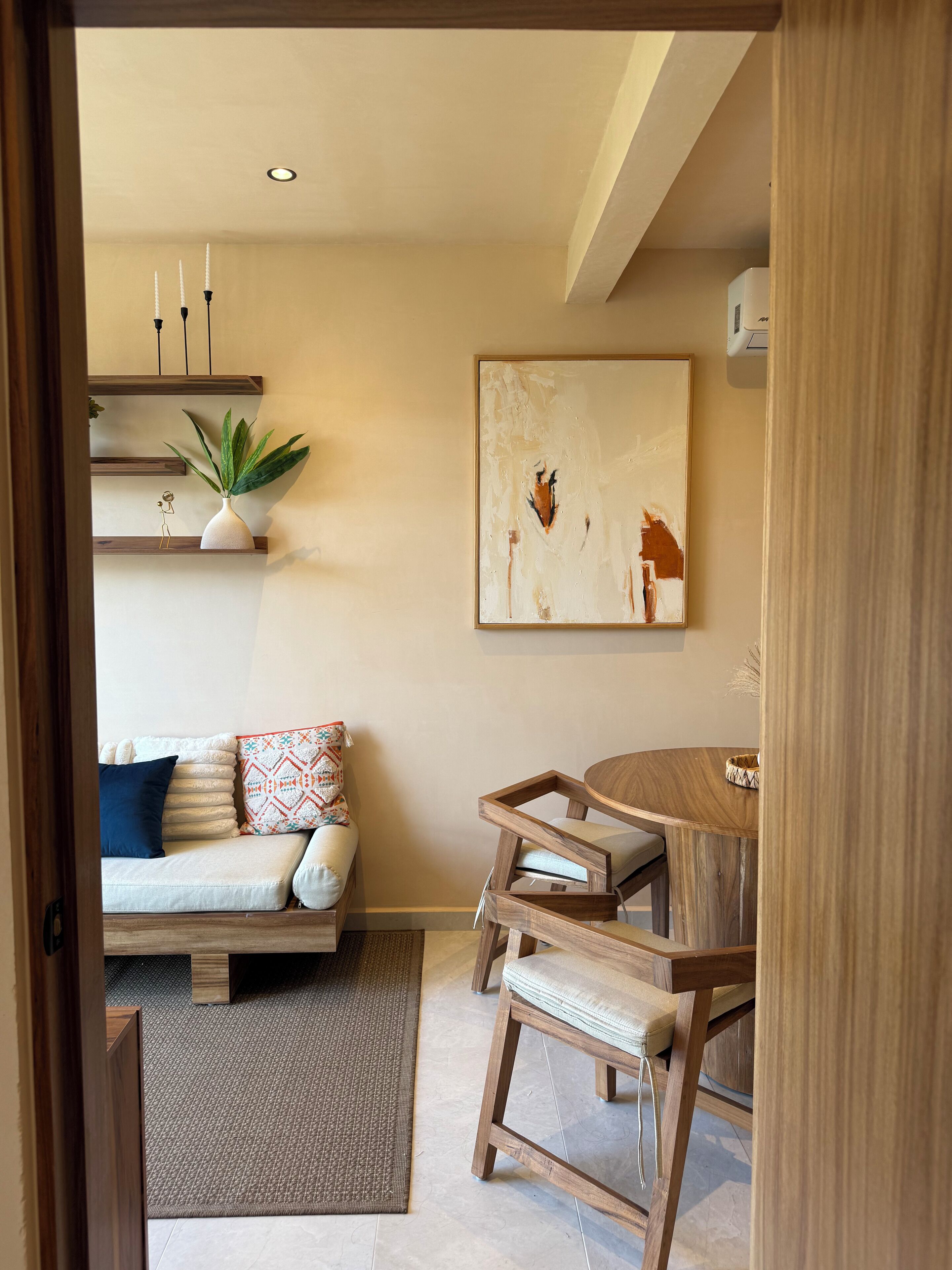 A modern living room with a sofa, a coffee table, and a painting on the wall.