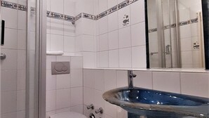A bathroom with a toilet, a shower, and a sink. - Strandvilla Hubertus - H1 - Marc Chagall (Ostseebad Boltenhagen)