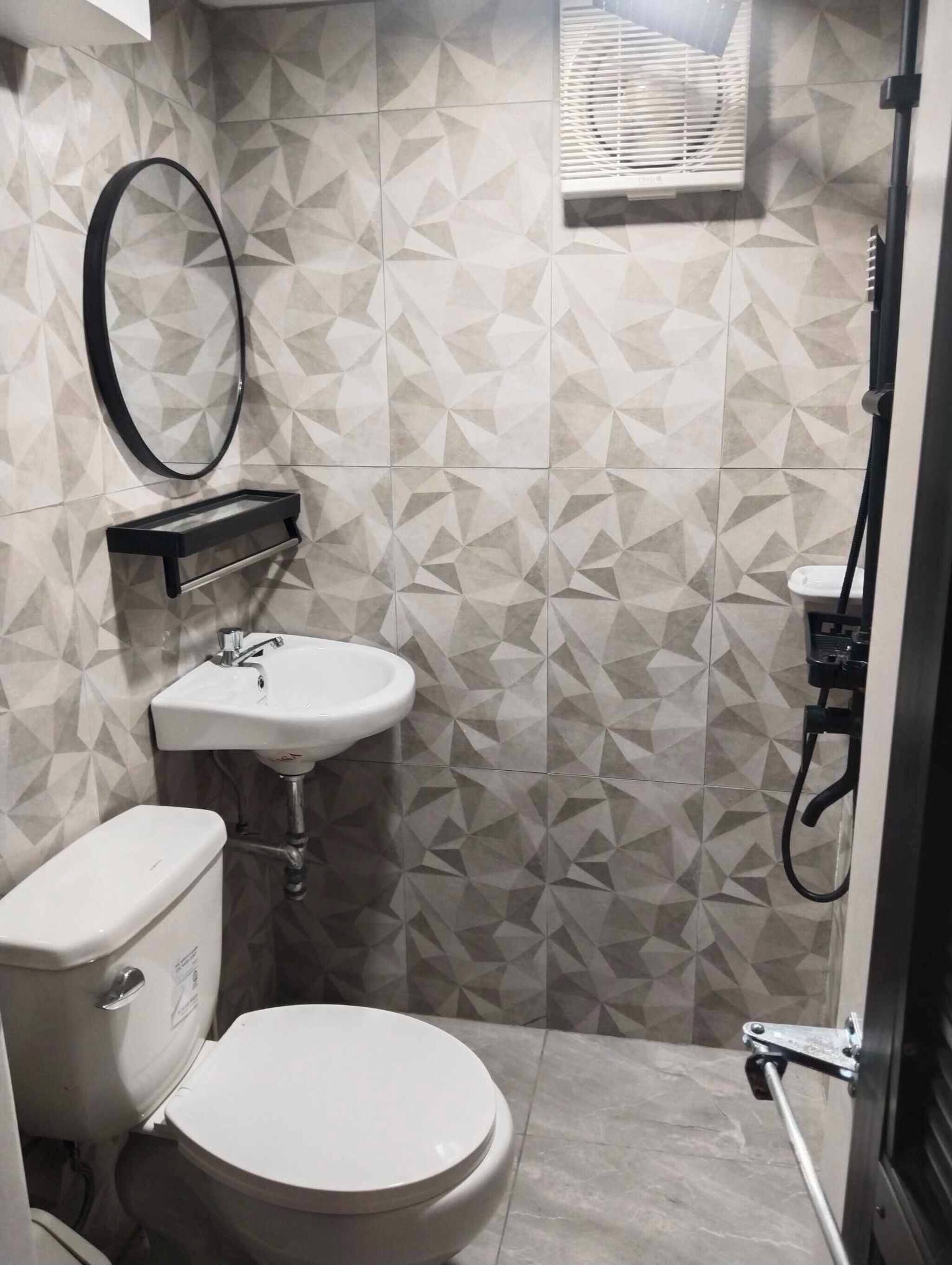 A compact bathroom with a toilet, sink, and shower.