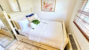 A bed with a white quilt, a blue pillow, and a green plant. - Oceanfront Escape 3BR 2BA Pool Parking Private Beach Access Loíza (Loíza)