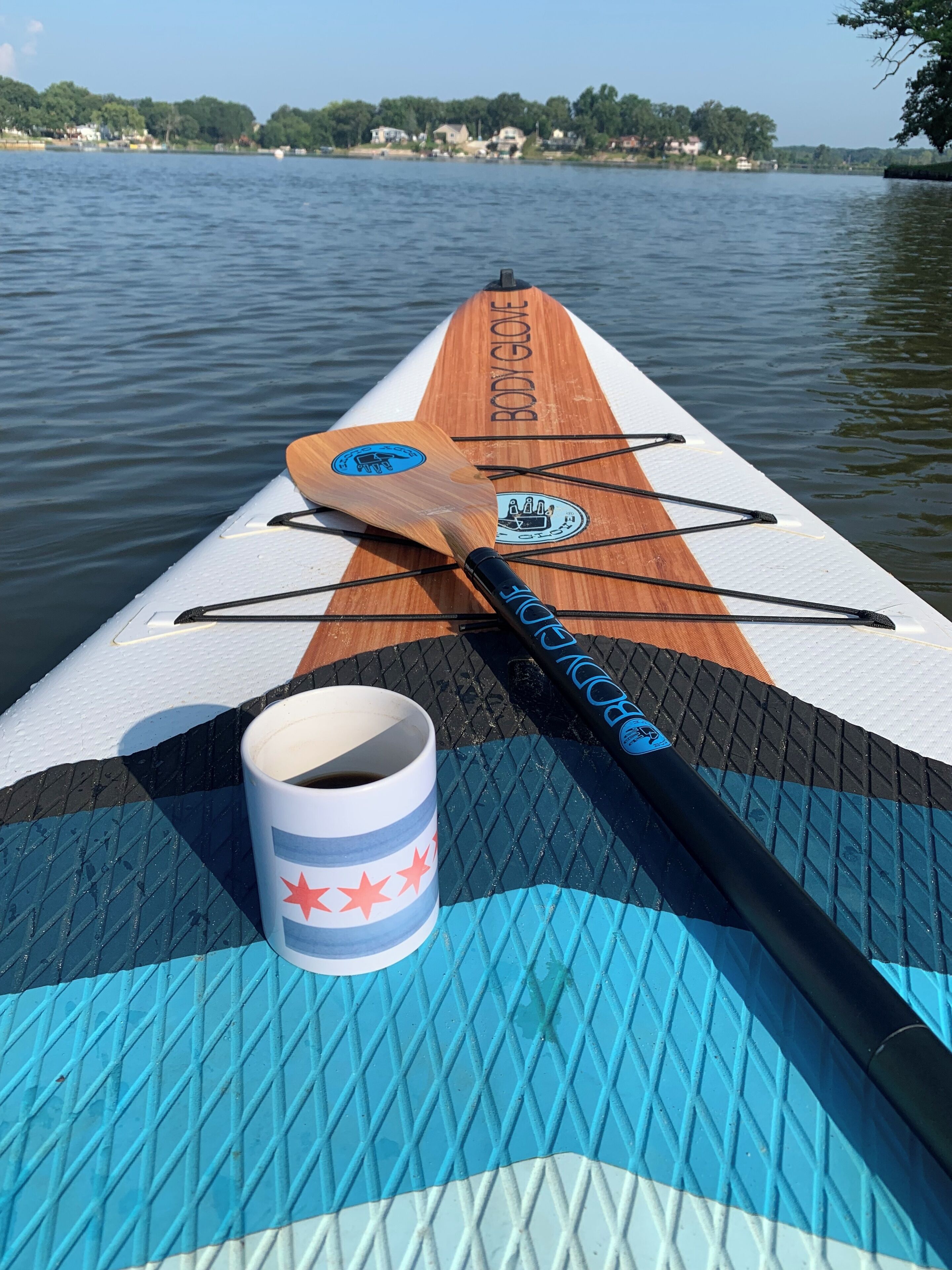 Ein Stand-Up-Paddleboard mit Tasse und Paddel.