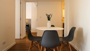 A dining area with a round table, four chairs, and a vase of flowers. - w* | Chic & Inviting 2BR w/ Balcony in Miraflores (Miraflores)