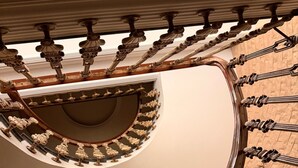 Una scala a chiocciola con ringhiere decorate e una elegante balaustra in legno lucido.