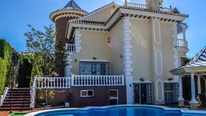 Una grande casa a due piani con una piscina nel cortile sul retro.