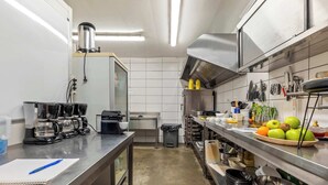 Una cucina moderna con elettrodomestici in acciaio inossidabile, una macchina per il caffè e una varietà di utensili e pentole.