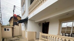 En bygning med en flisbelagt gårdhave, en balkon med balustrader og et vindue med udsigt.