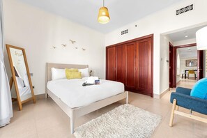 Ein Schlafzimmer mit einem Bett, einem Holzschrank, einem Spiegel und einer Pendelleuchte.