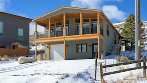 A two-story house with a covered porch and a garage. - Panoramic Views | 13 Min to Winter Park | Sleeps 8 (Tabernash)
