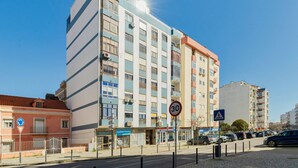 A multi-story building with a pedestrian crossing sign, a speed limit sign, and a parking sign. - Serra&Rio no Sado - By Y Concept (Setúbal)