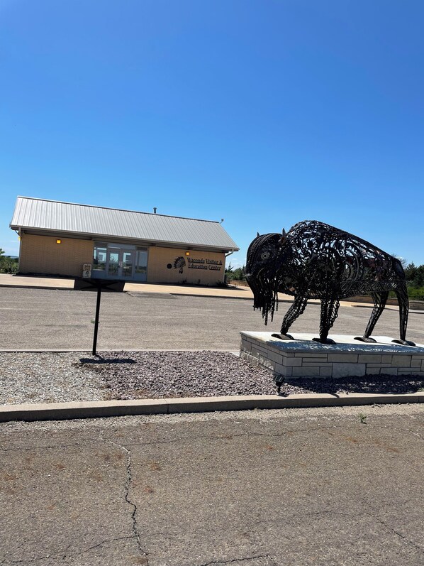 Un edificio con la leyenda 'Waconda Visitor & Education Center' y una escultura de metal de un búfalo en su fachada.
