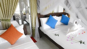A hotel room with a bed, a window with curtains, and a decorative swan on the bed.