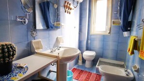Un baño con lavamanos, inodoro y zona de ducha.
