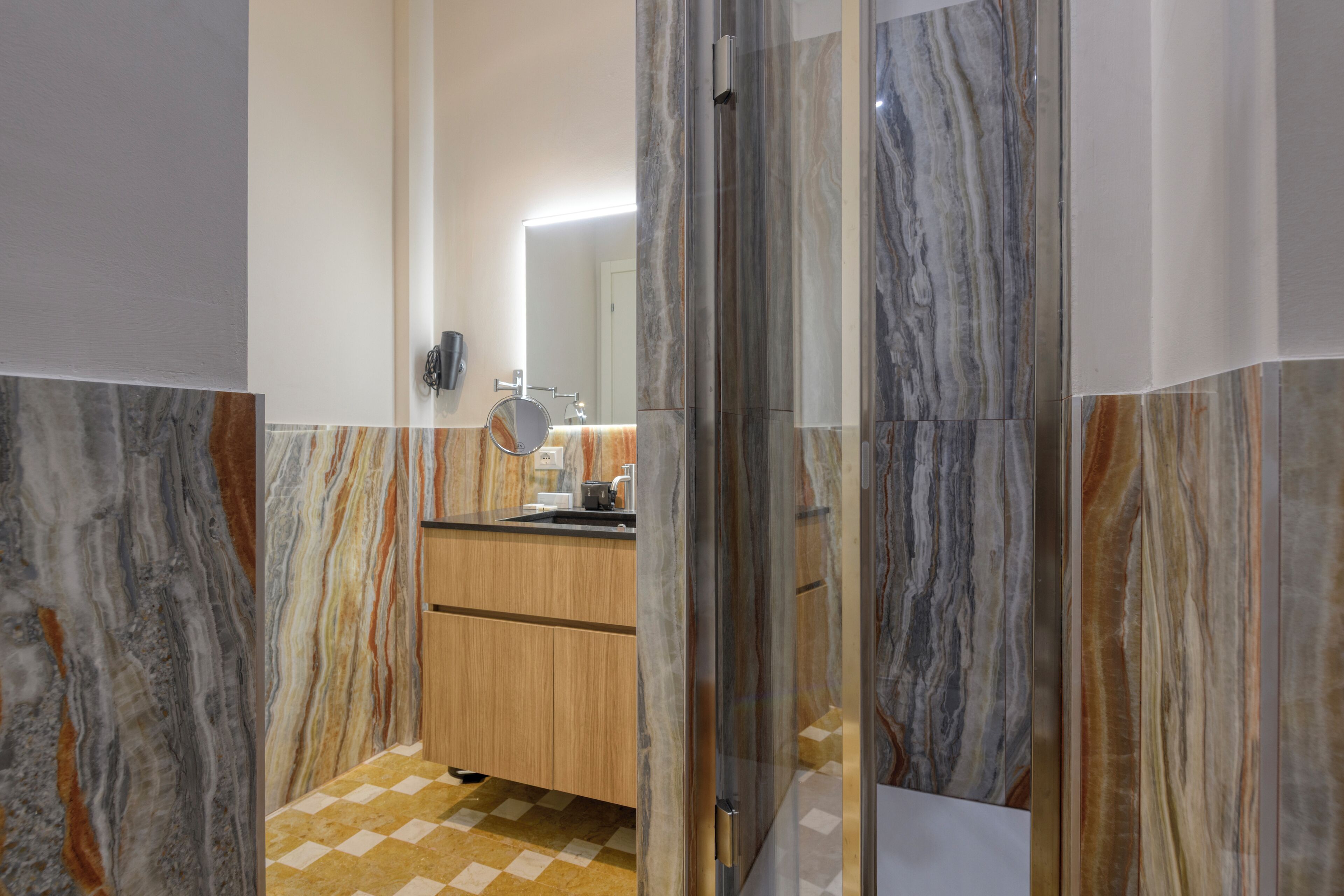 A bathroom with marble walls and a checkered floor.