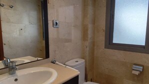Un bagno piccolo con lavandino, WC e specchio.