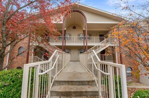Un immeuble à plusieurs étages doté d’un escalier central, d’une façade en briques et d’un balcon situé à l’étage supérieur.