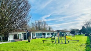 Un barrio residencial con casas, un campo cubierto de césped y juegos infantiles.