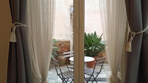 A room with a sliding glass door leading to an outdoor patio area. - Città Giardino B&B - Un'oasi di tranquillità vicino la metro Conca d'Oro (Roma)