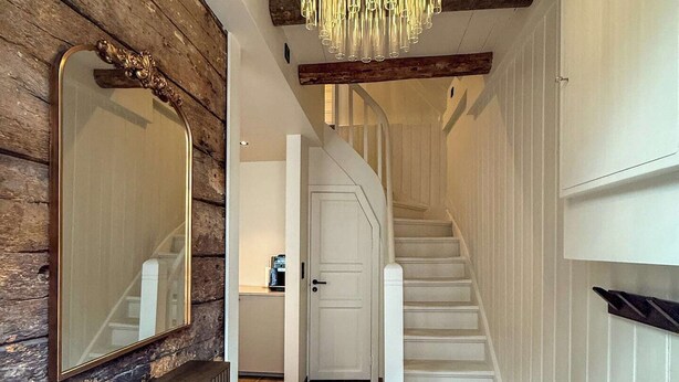 A wooden interior with a staircase, a chandelier, and a mirror. - Homey house in the heart of Bergen on a quiet street (Vestland)