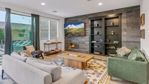 A modern living room with a sofa, a coffee table, a fireplace, and a bookshelf. - The Headliner:Private! Game Room! Festivals! (Coachella)