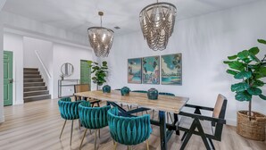 A dining area with a wooden table, teal upholstered chairs, and a chandelier. - The Headliner:Private! Game Room! Festivals! (Coachella)