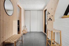 A hallway with wooden walls, a bench, a mirror, and a small table. - Holiday home near beach and Limfjord (Thyholm)