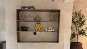Een wandplank met decoratieve objecten en een plant in pot.