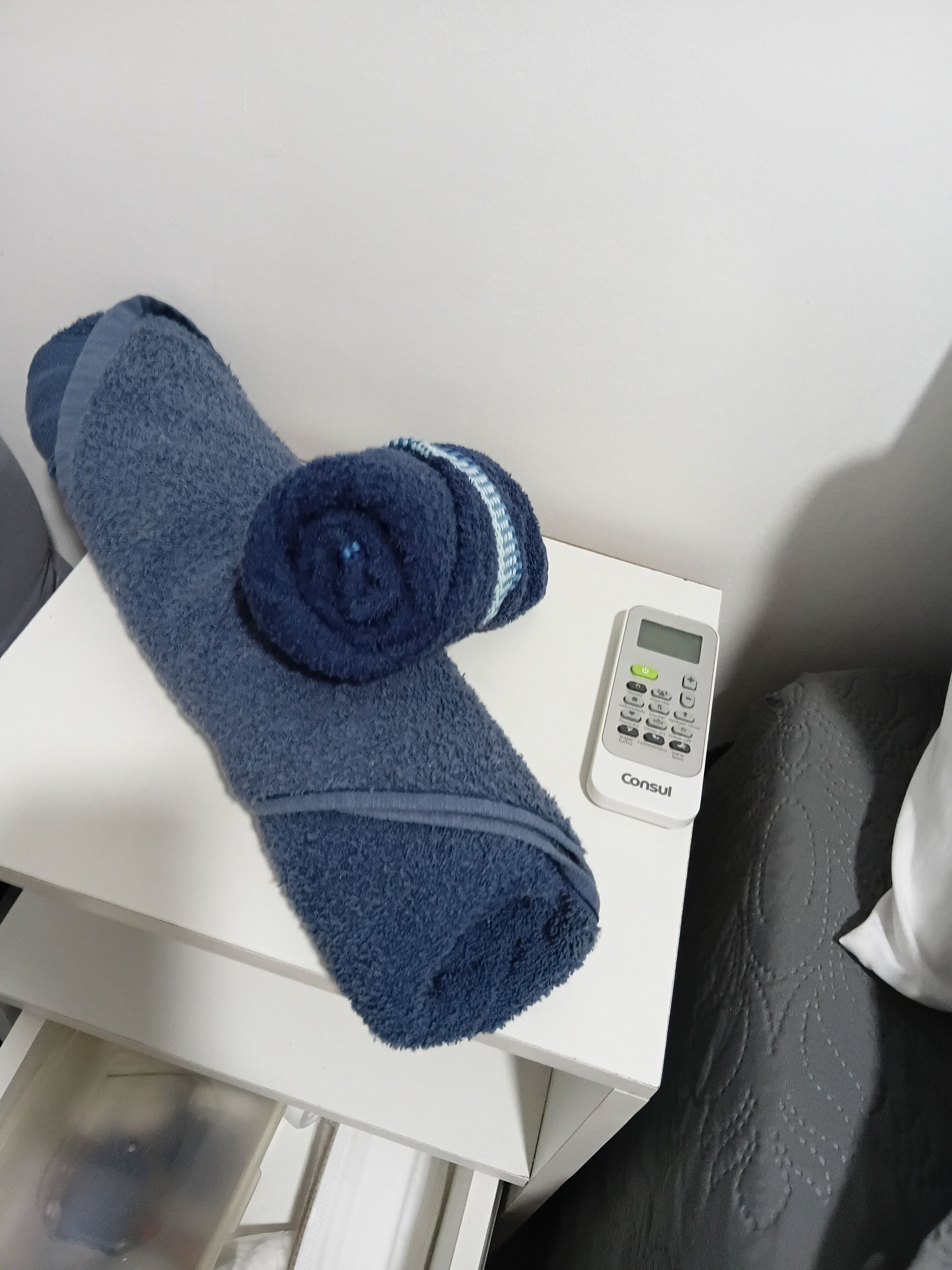 A white box with a blue towel and a Consul brand electronic device on top.