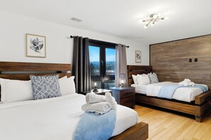 A hotel room with two beds, a wooden headboard, a nightstand with a lamp, and a view through a window. - Sleeps 24! Luxury, Sauna, Hot tub, Zen room, Gameroom, pets (Tannersville)